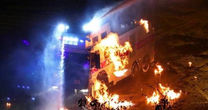 A riot police vehicle is set on fire during clashes outside Hong Kong Polytechnic University (PolyU) in Hong Kong, China