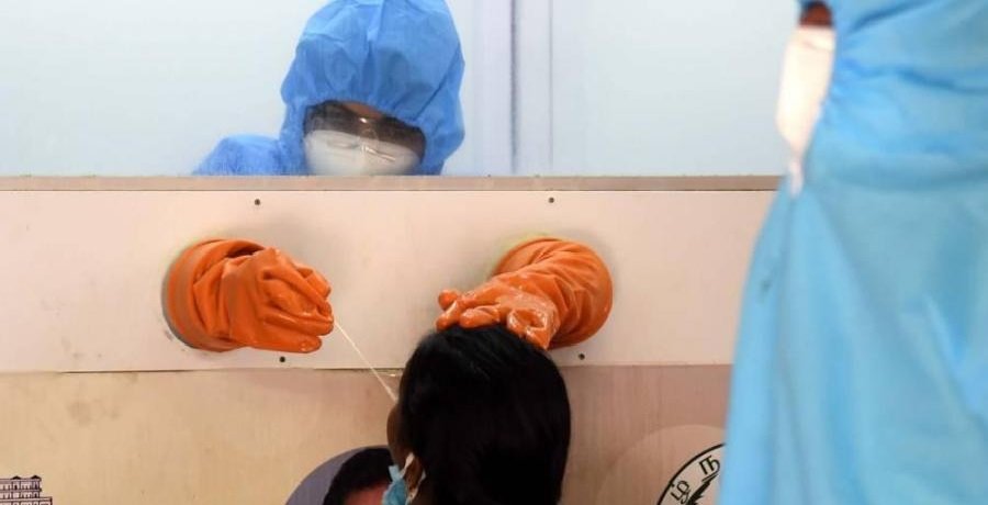 A health worker in a protective chamber collects samples for a swab test at Chennai's Saidapet during lockdown.